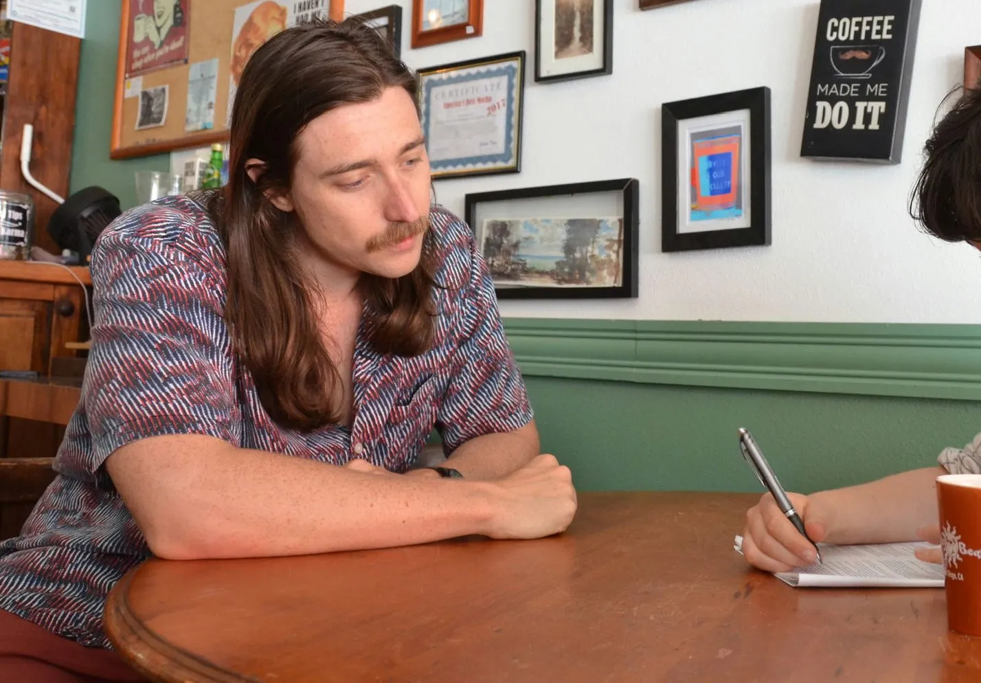 Nick working through a practice section with a student at a cafe table